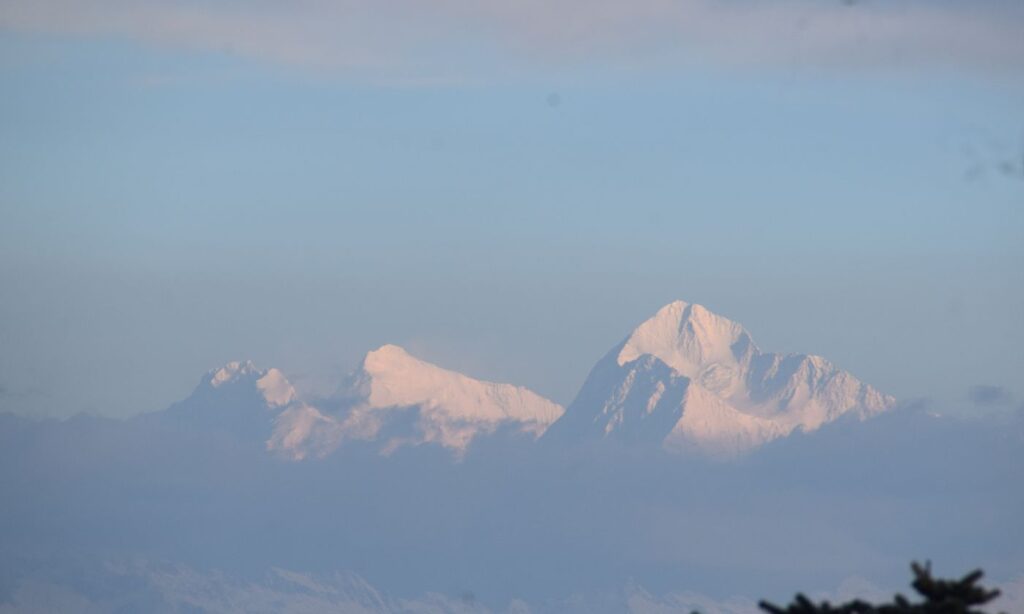 First light hitting the snow-capped Everest cluster, showcasing Lhotse on the left alongside Mt. Makalu, as seen from Sandakphu.